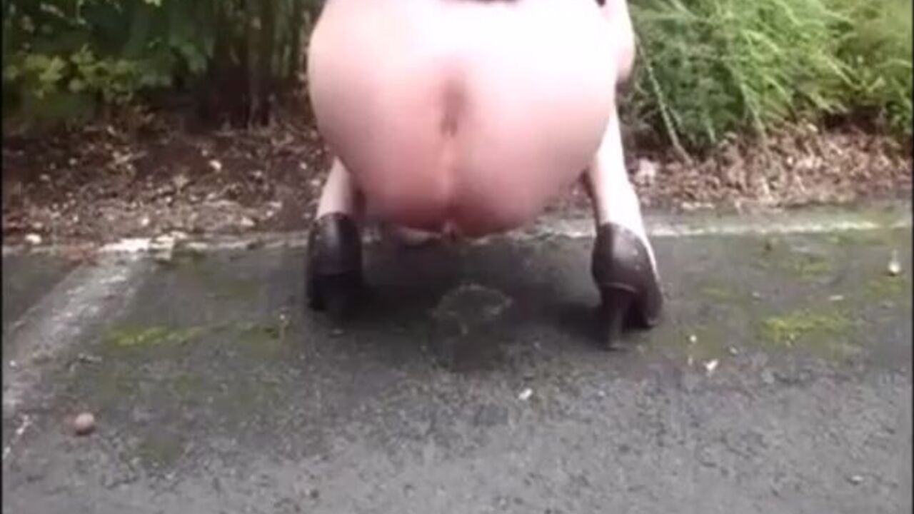 Watch this filthy mature lady pissing and taking a big load on the road